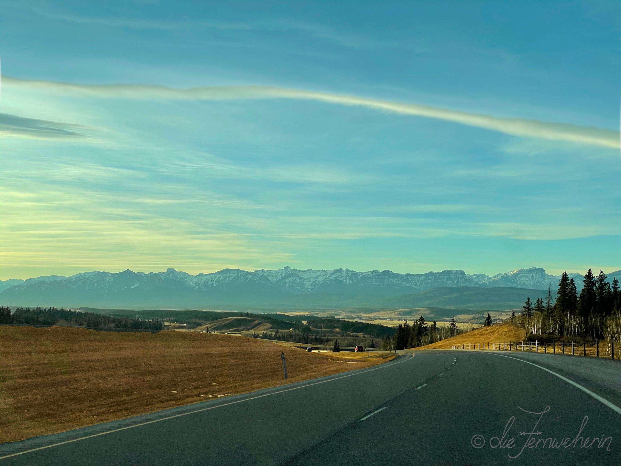 Highway 1 WB heading from Calgary, Alberta towards Banff National Park, as the sun starts to set.