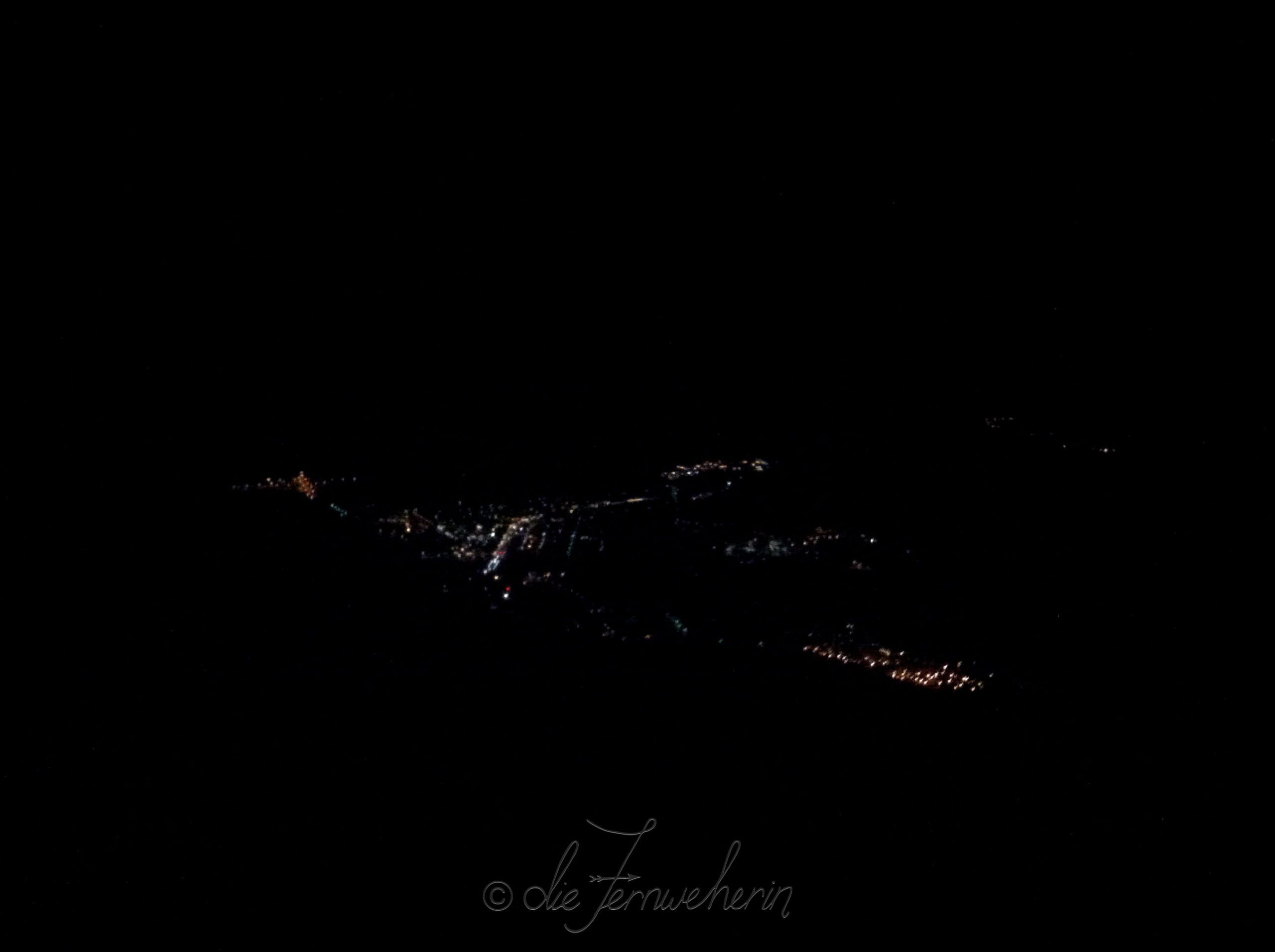 The town of Banff lit up by streetlights, as seen from the gondola at night.