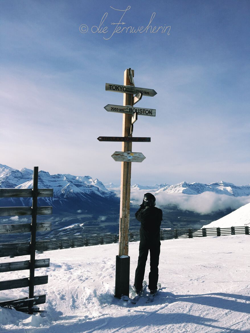 A skier takes a photograph of the mountain views at Lake Louise Ski Resort in Banff National Park.