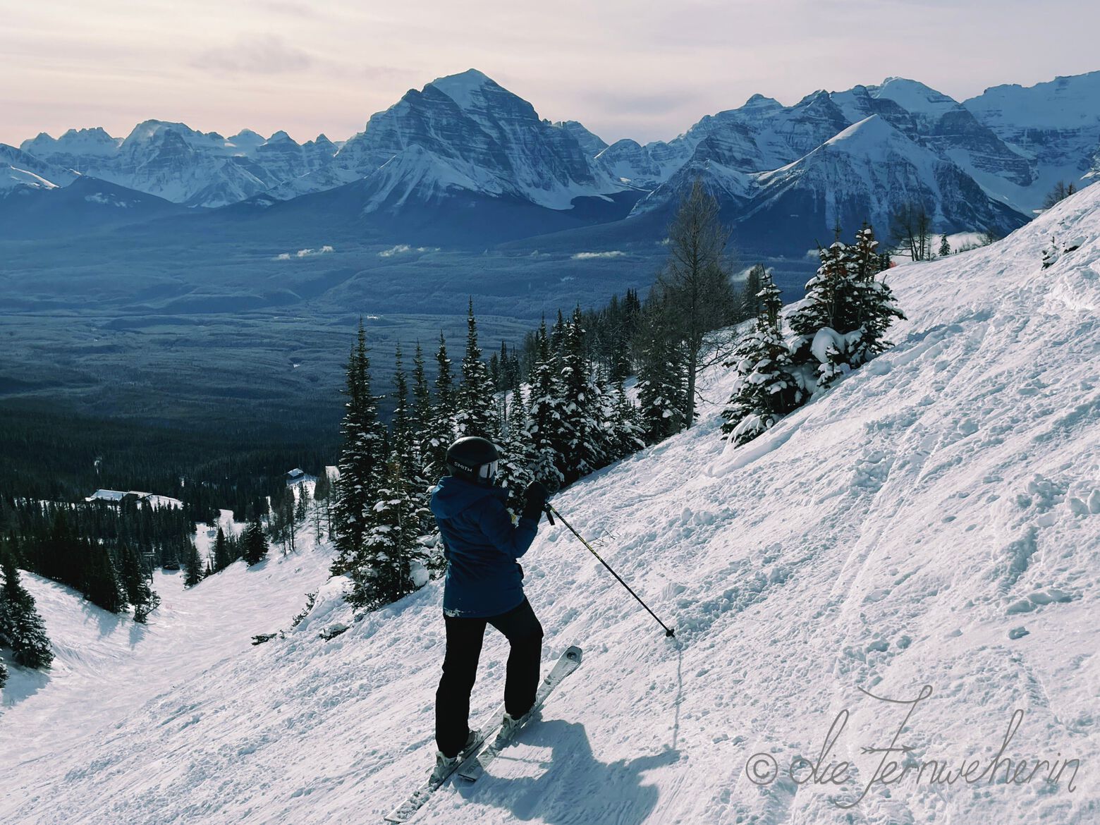 A skier poses on a steep slope at Lake Louise Ski Resort in Banff National Park.