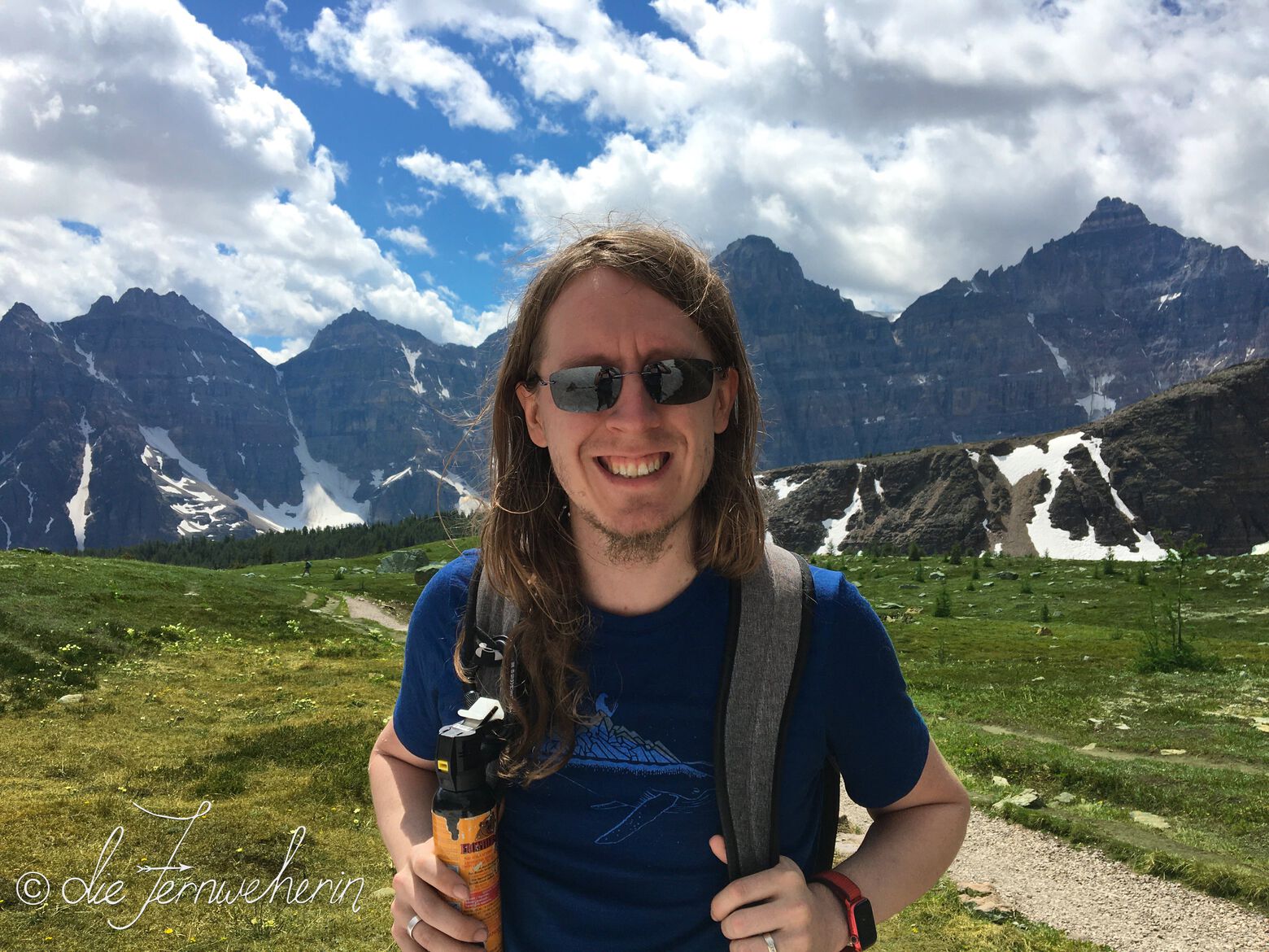 A hiker on the Larch Valley Trail in Banff National Park poses with his bear spray & backpack.