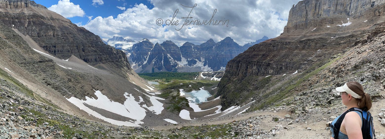 A woman looks out over Minnestima Lakes and the Valley of the Ten Peaks from the top of Sentinel Pass in Banff National Park.