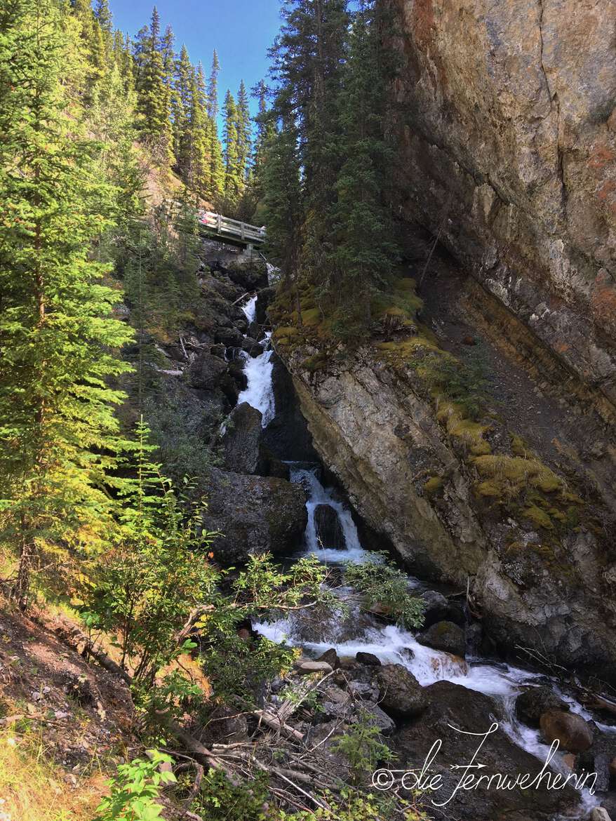 A bridge crosses a cascading waterfall at Sundance Canyon on the outskirts of the town of Banff.