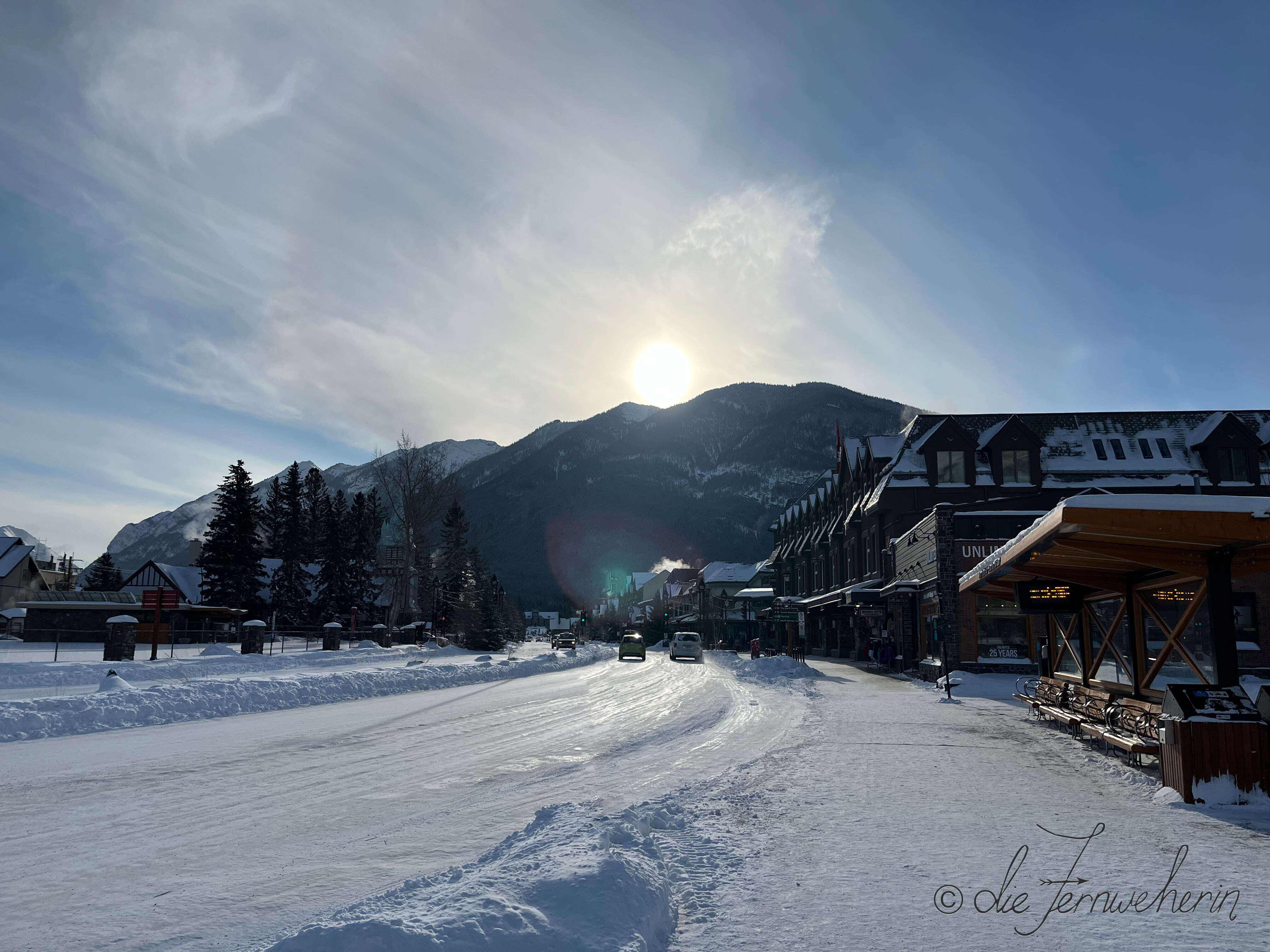 View of downtown Banff in the winter, as the sun sets behind Sulphur Mountain.