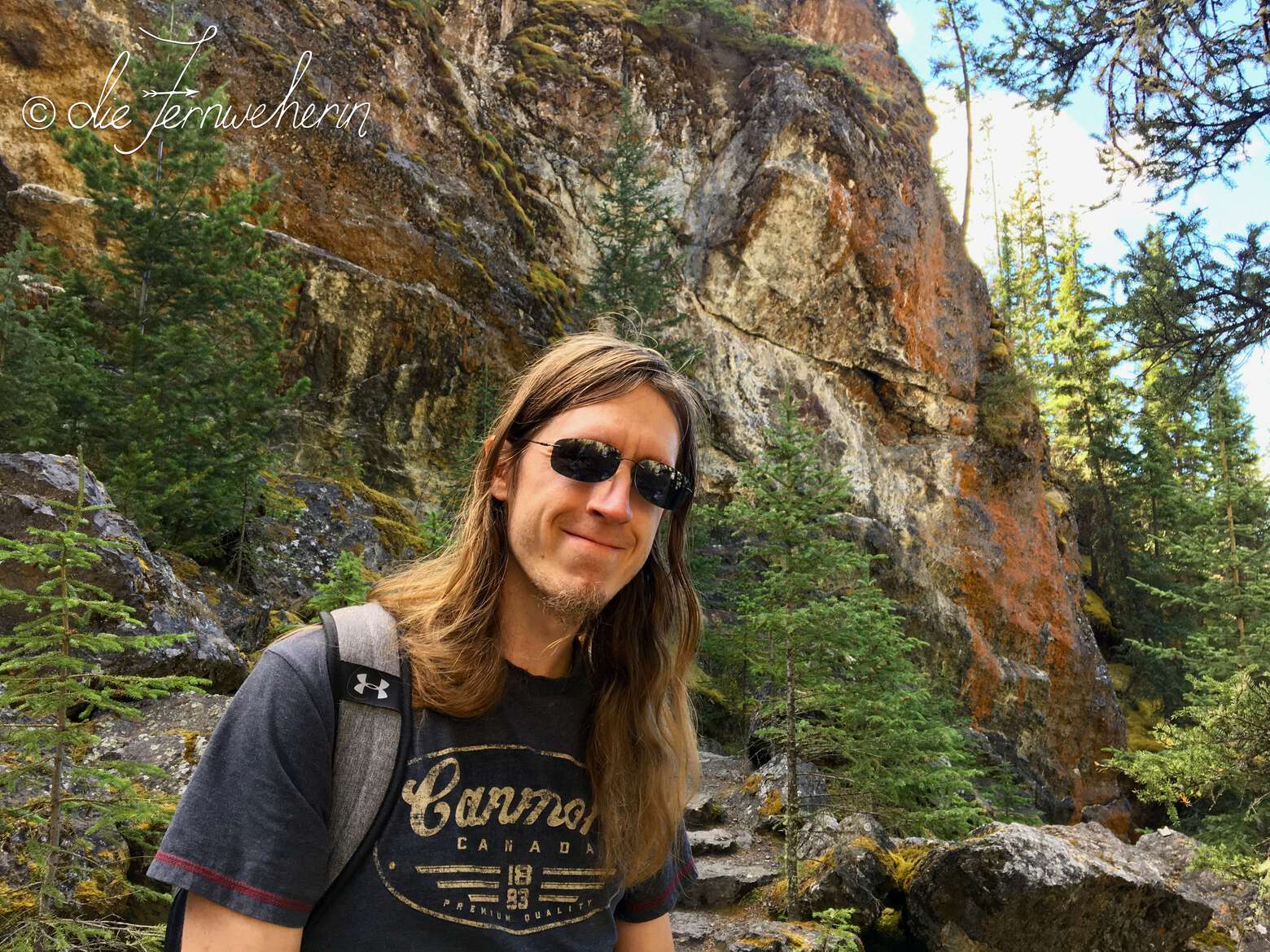 A hiker poses in front of the rock wall of Sundance Canyon in the town of Banff.