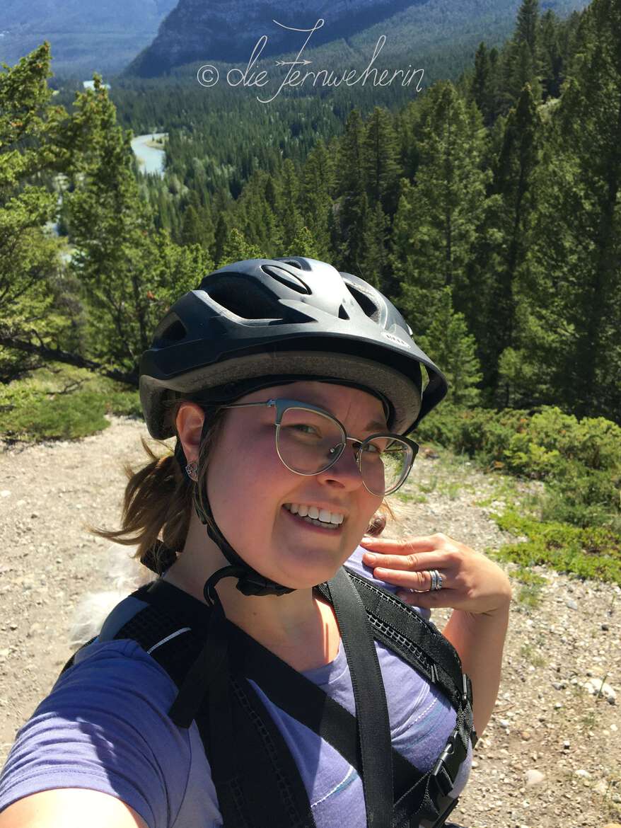 A female cyclist poses for a selfie at the Hoodoos Viewpoint in the town of Banff.