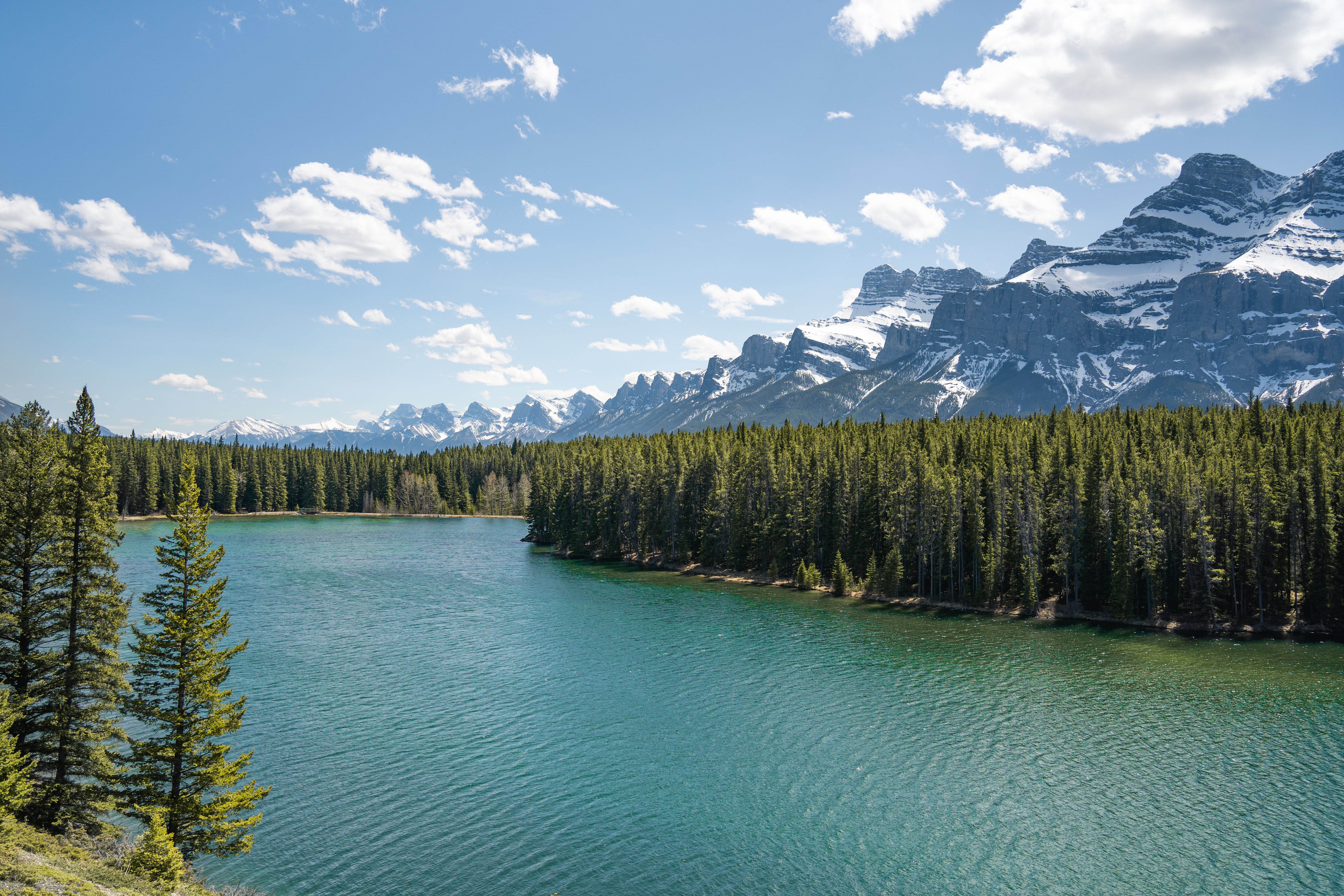 Johnson Lake, in Banff National Park, surrounded by snow-capped mountains and a forest of conifers.