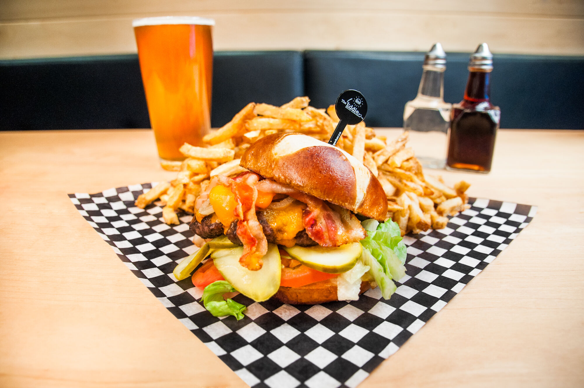 A burger (topped with cheese, bacon, pickles, and more) with a side of fries at The Eddie Burger + Bar, a restaurant in the town of Banff.