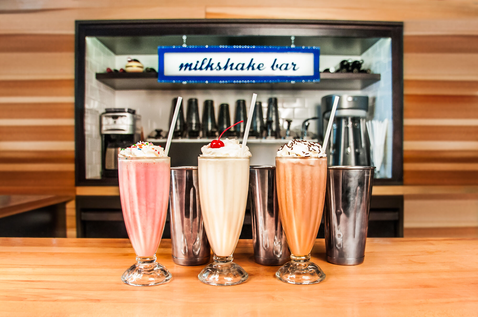 Three milkshakes in a line on the counter at The Eddie Burger + Bar, a restaurant in the town of Banff.