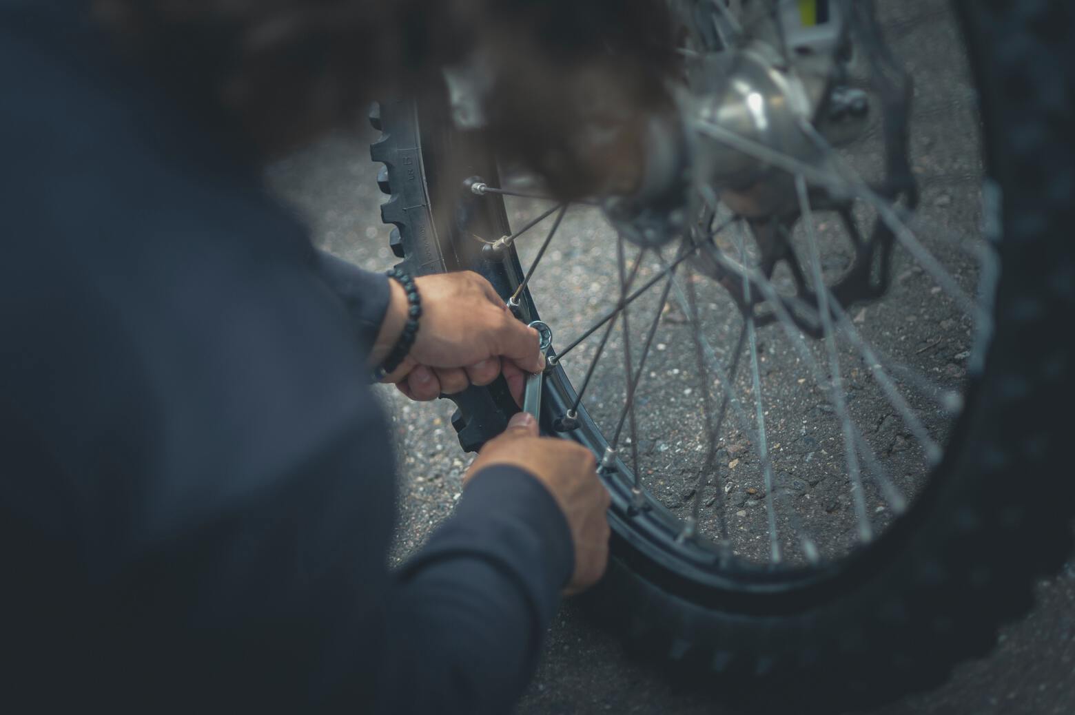 A man performs repairs on a bike tire.